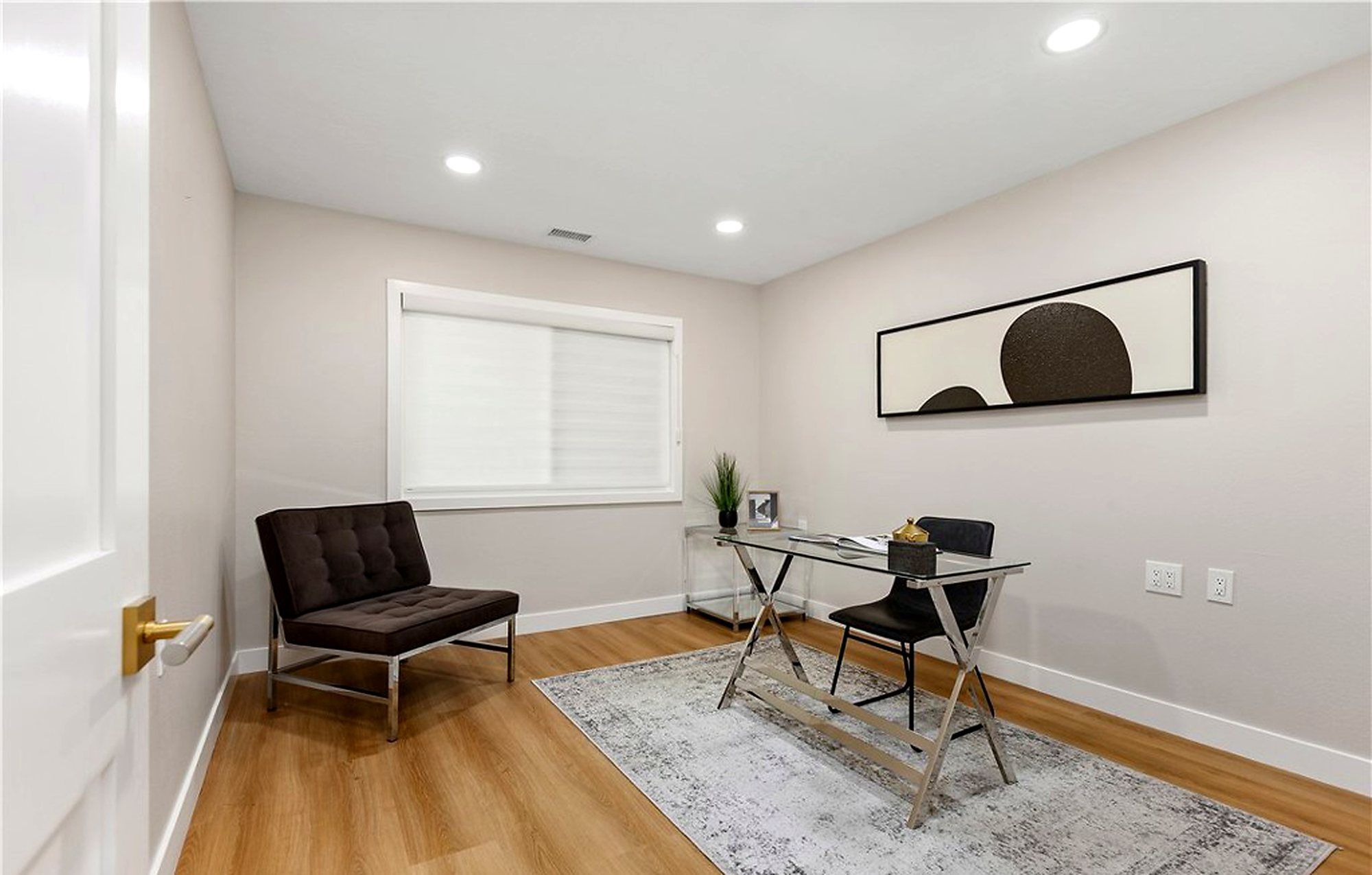 Second bedroom staged as an office with a glass desk and a leather chair, Laguna Woods