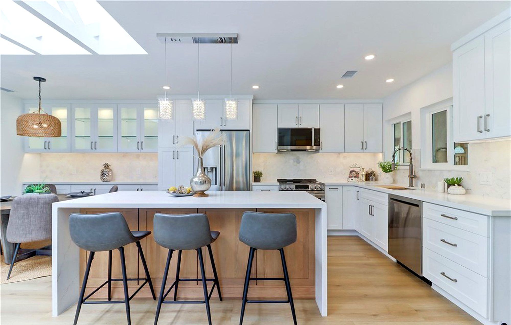 White kitchen under skylights, with a woven pendant over the dining nook, Laguna Woods