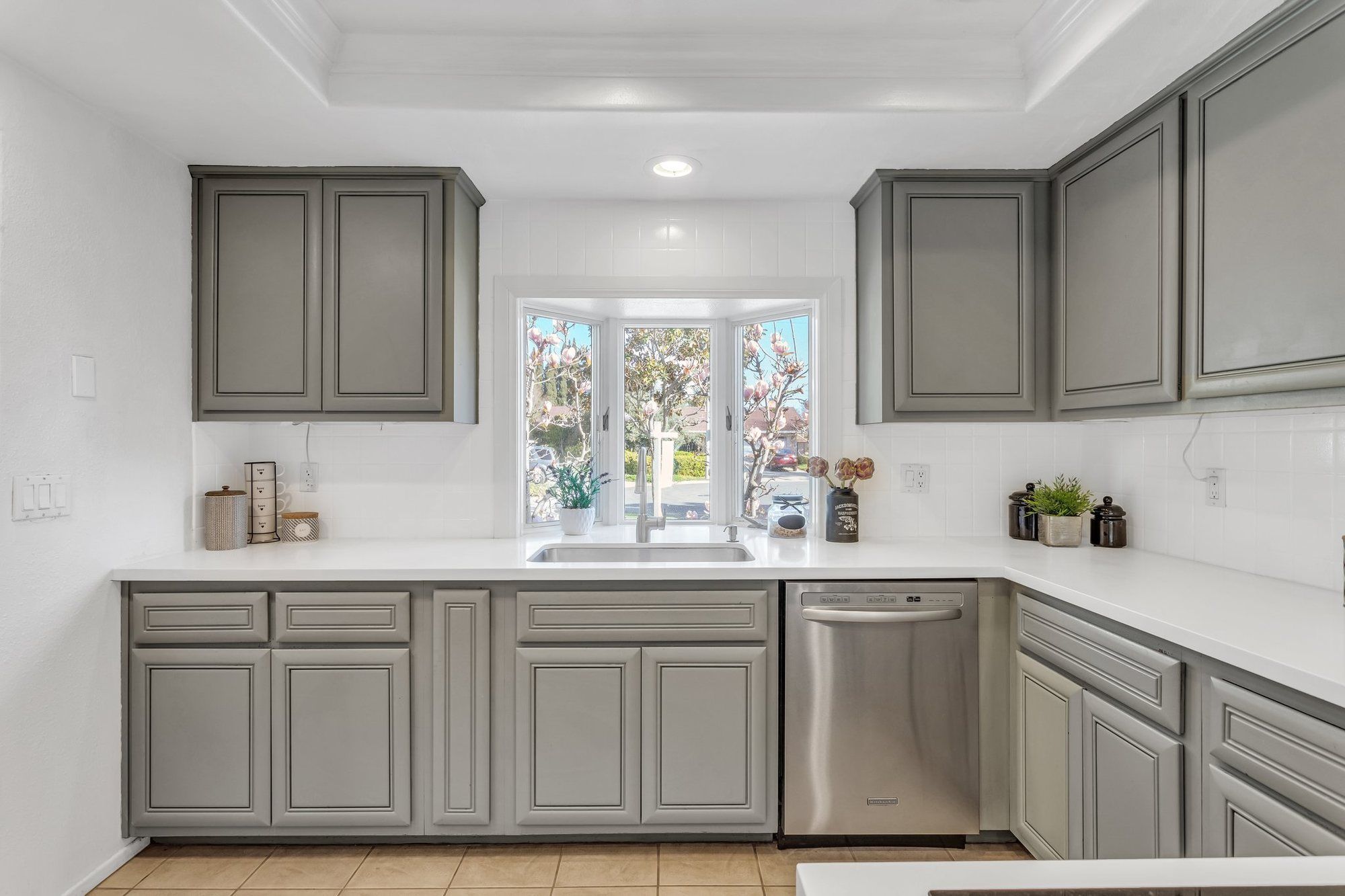 Sage-gray cabinets around a garden window, Tustin