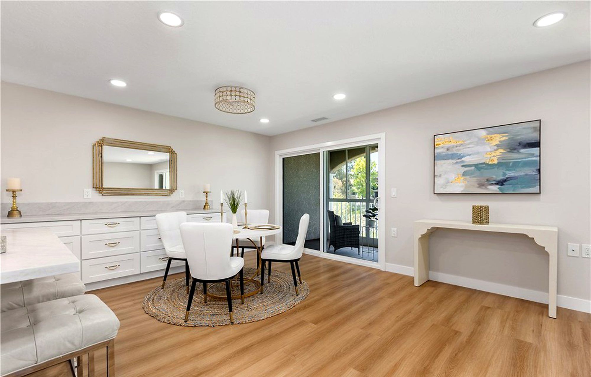 Round white dining table with white chairs beside built-in cabinets, Laguna Woods