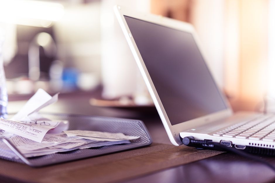 desk with laptop and receipts