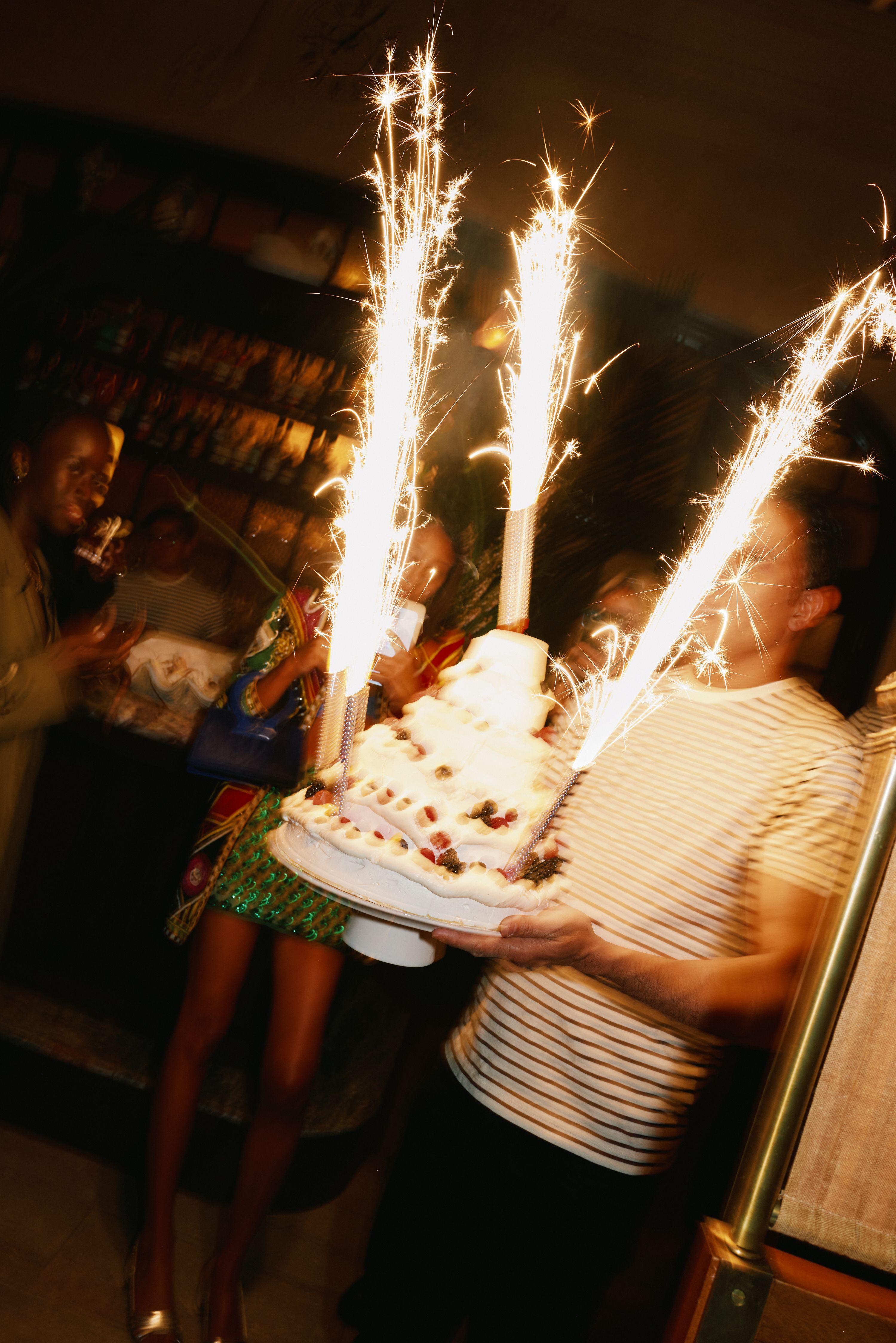 Person holding cake with sparklers