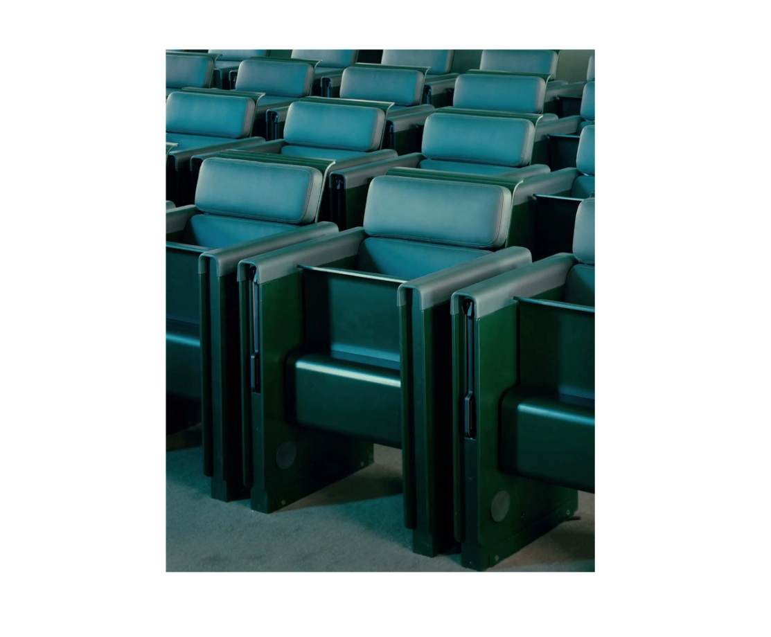 Rows of green upholstered auditorium seats