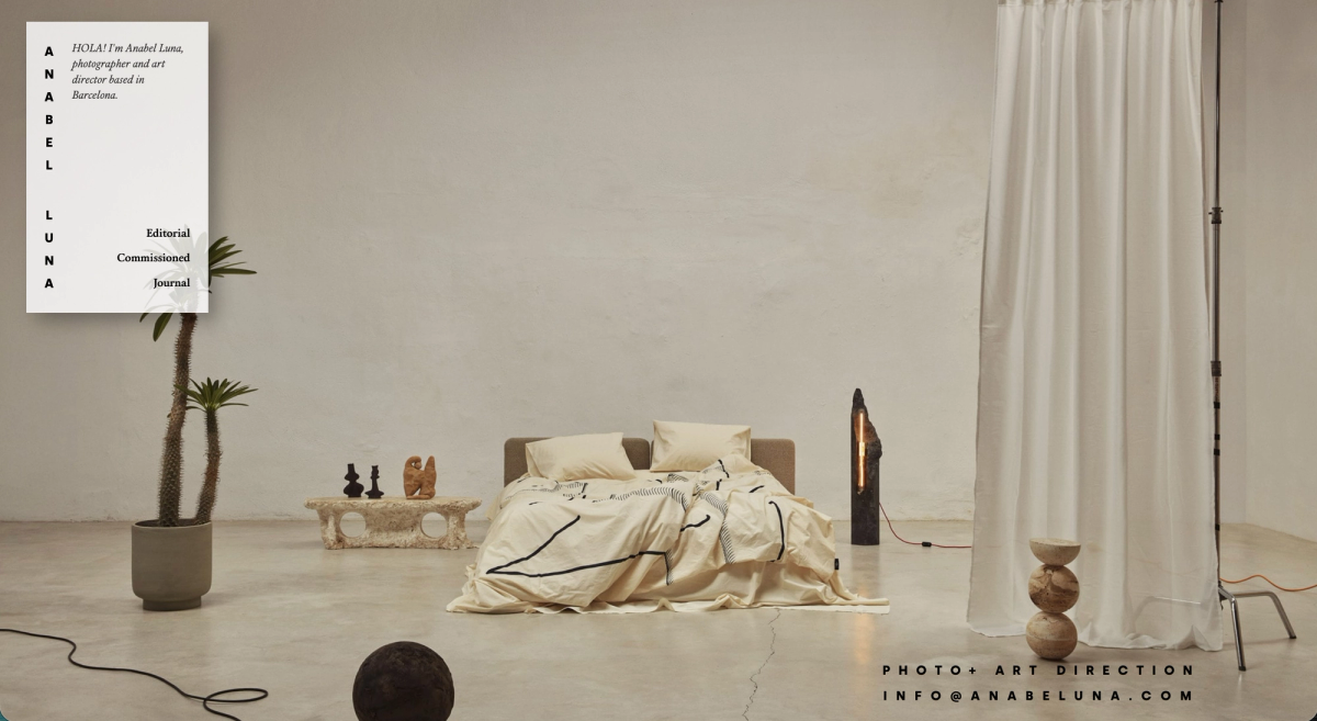 Anabel Luna home page: a bed with a lamp and plants in a bright studio, with the photographer's card