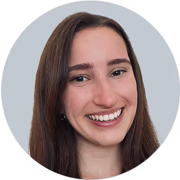 Woman with long dark hair smiling at camera against gray background