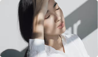 Person with eyes closed, face half in shadow and half illuminated by light