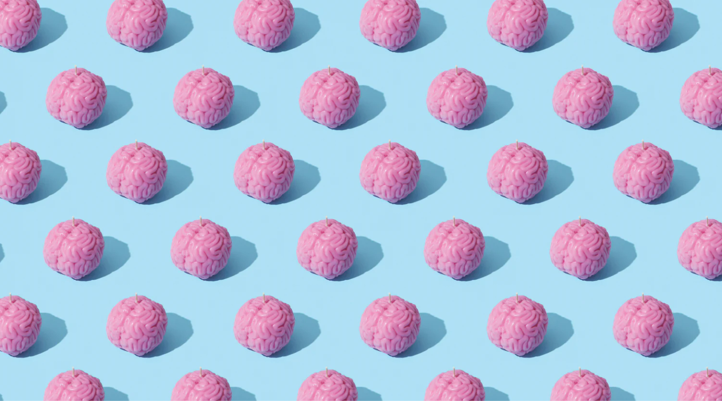 Repeating pattern of pink brain models on light blue background
