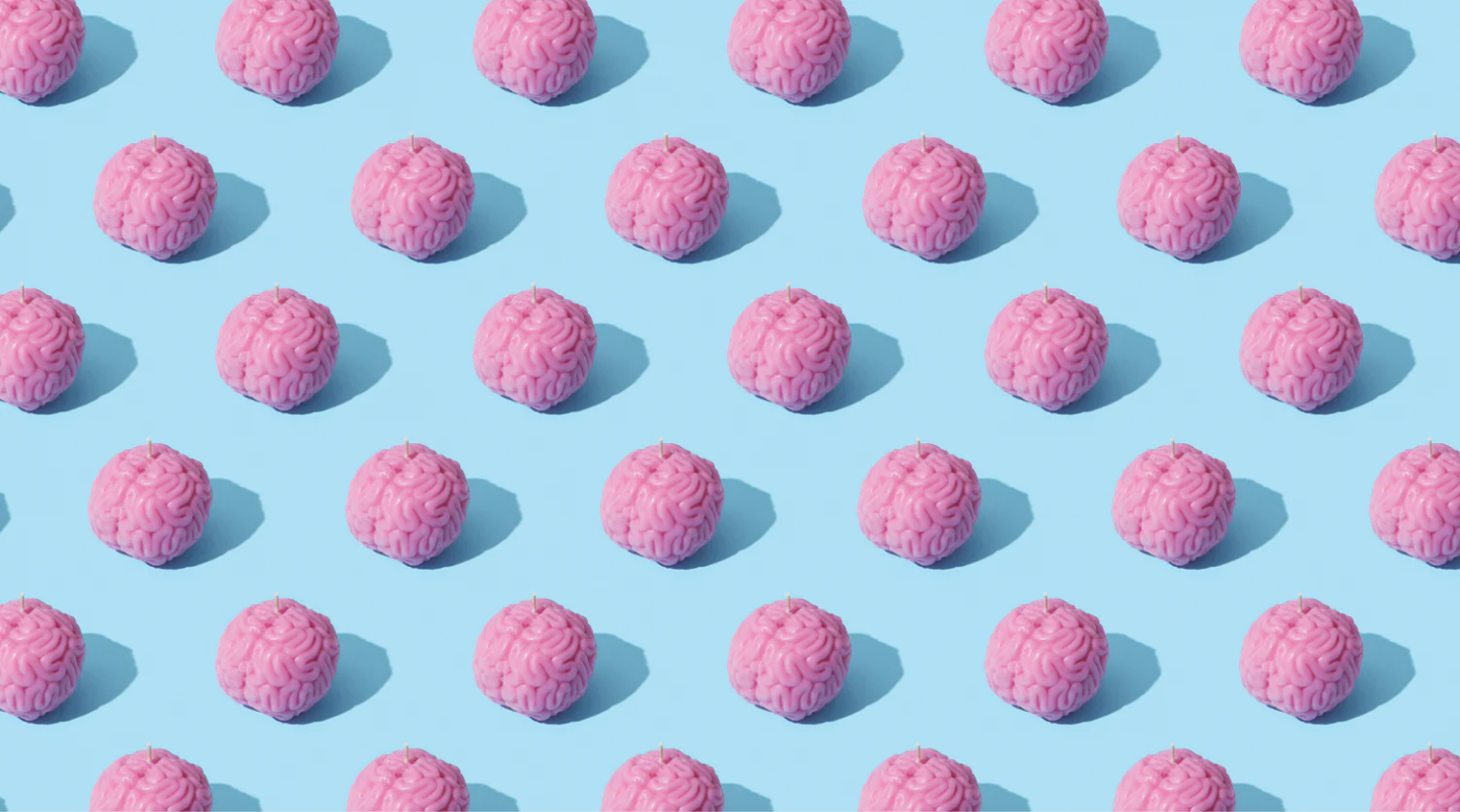 Repeating pattern of pink brain models on light blue background