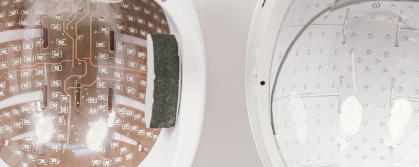 Interior view of Neuronic Helmet showing brown circuit board with light-emitting diodes on left and white dome with emitter array on right