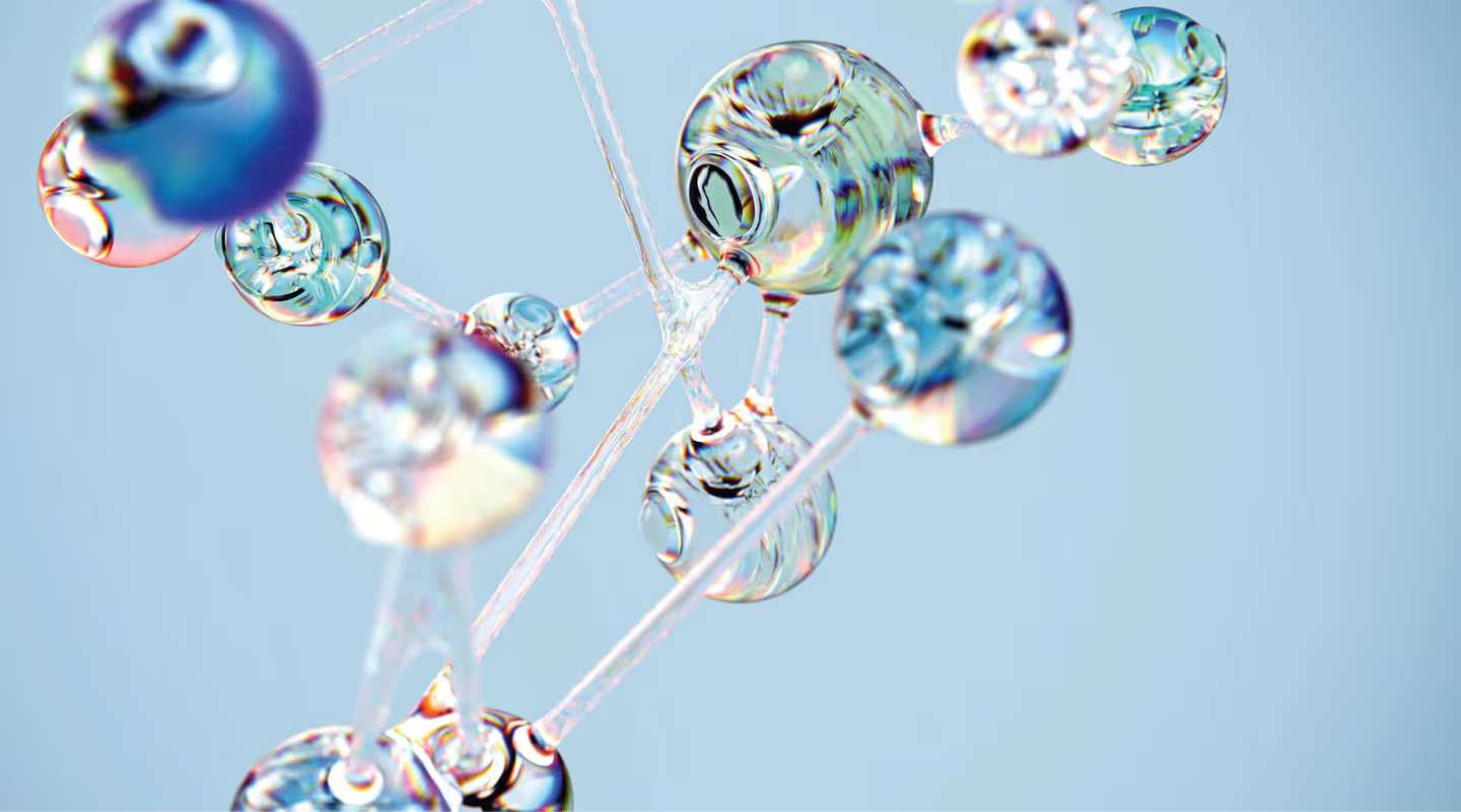 Transparent liquid droplets suspended on thin strings against a light blue background, refracting rainbow colors