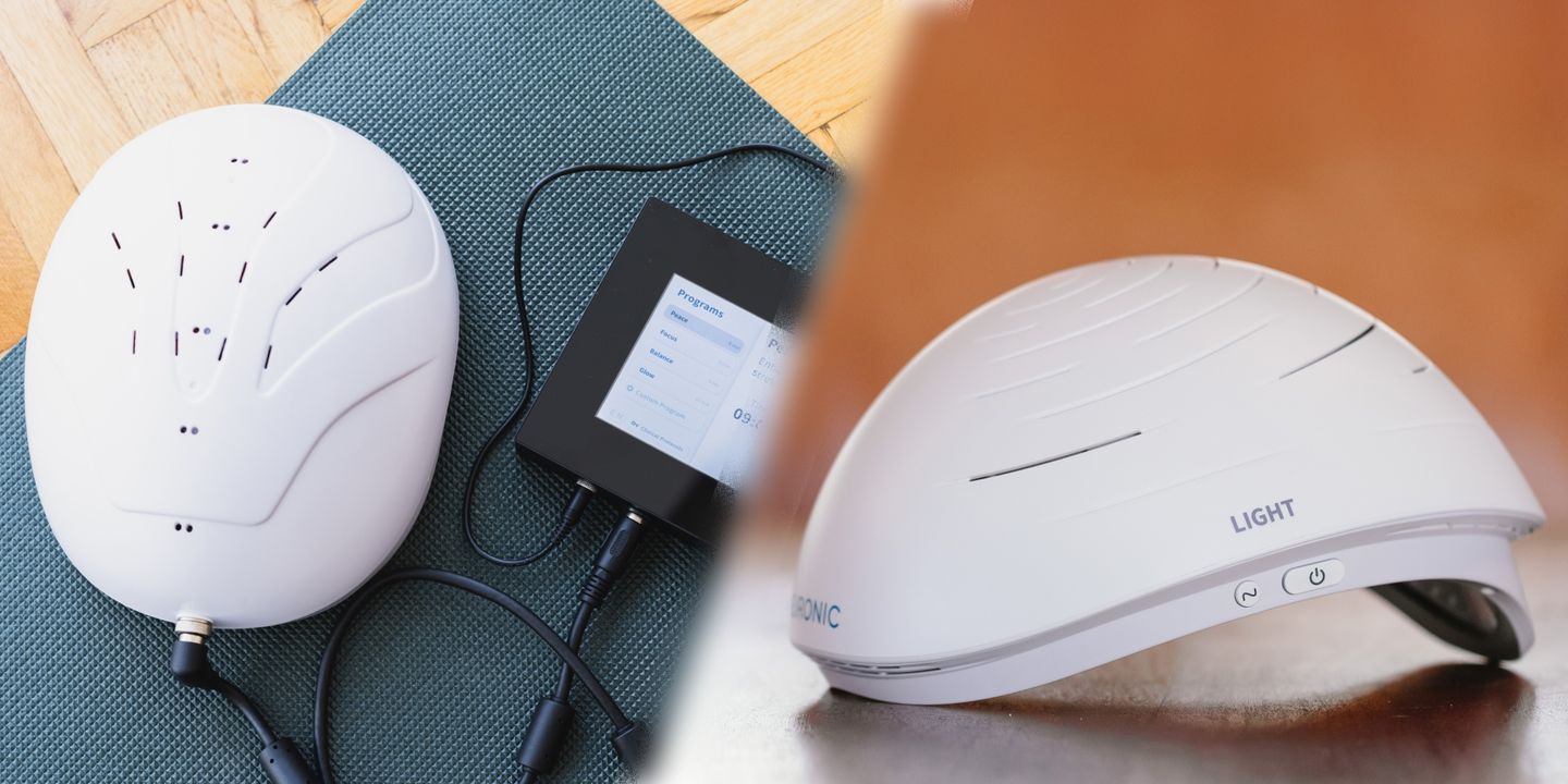 Two Neuronic light-therapy helmets on a blue mat with a black power supply unit, one helmet showing stimulation points marked on its surface