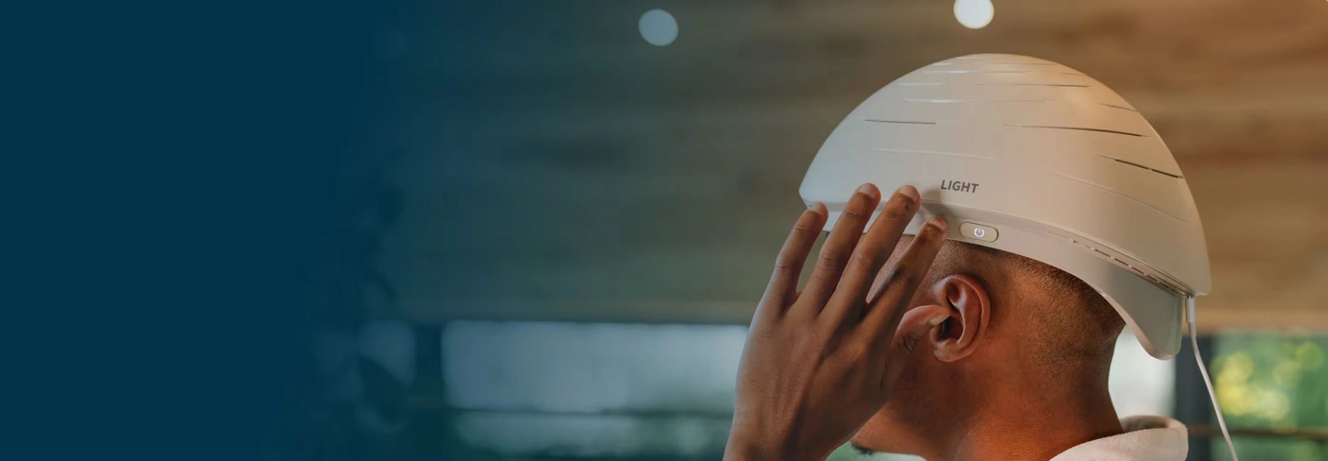 Person wearing Neuronic LIGHT helmet with hand raised to side of head
