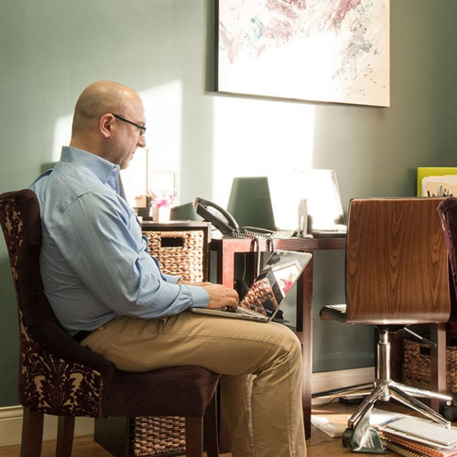 A clinician working at a desk inside Sharlin Health & Neurology in Ozark.