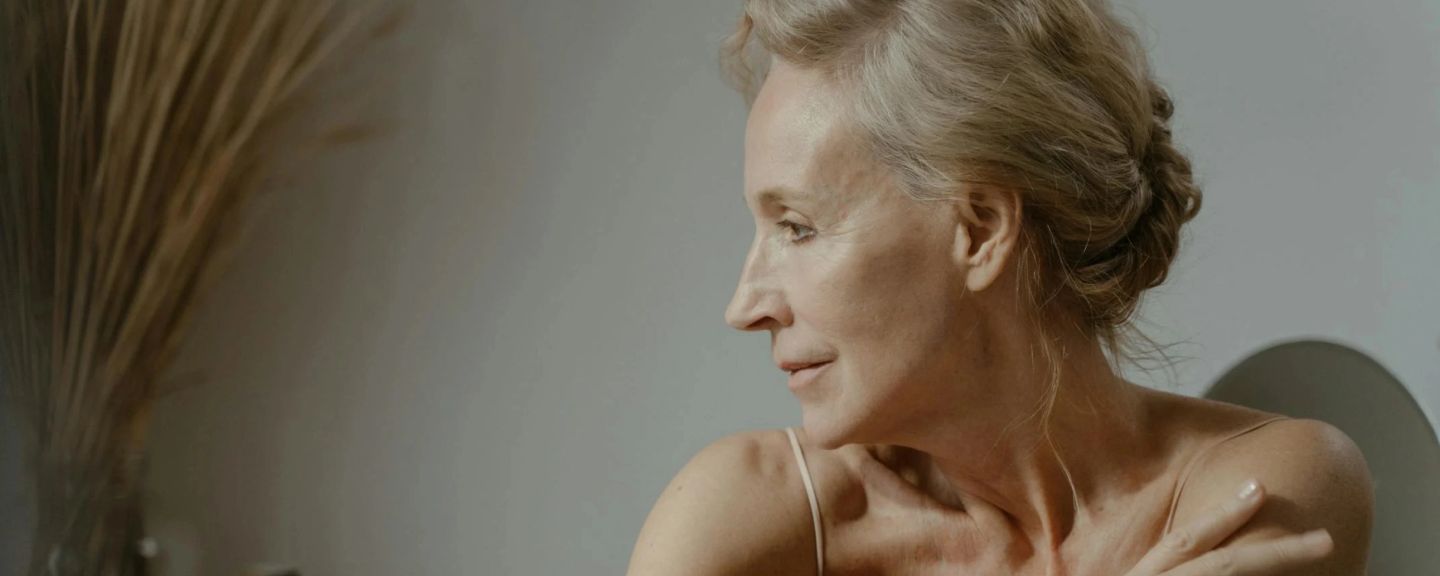 Woman with gray hair in profile, looking downward