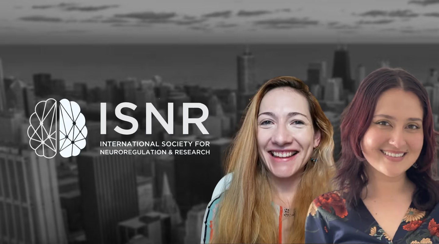 Two women smiling in front of a cityscape background with the ISNR logo and text for International Society for Neuroregulation & Research