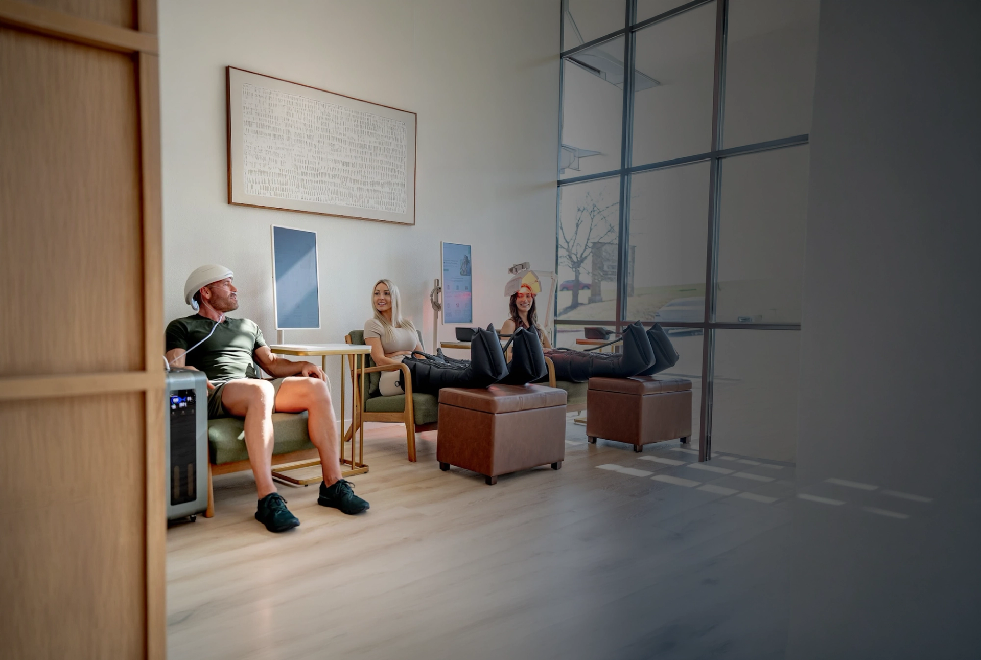 Clients relaxing in a wellness clinic treatment room while a client wears a Neuronic device