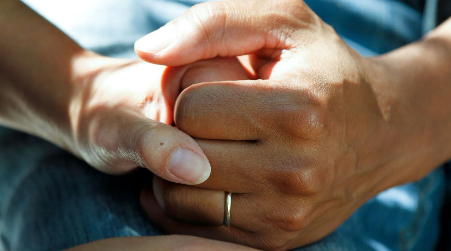 Adult's hand holding infant's hand