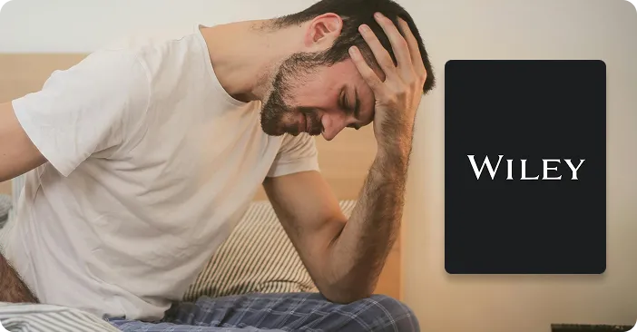 Man with hand to head appearing distressed, sitting on bed next to Wiley logo