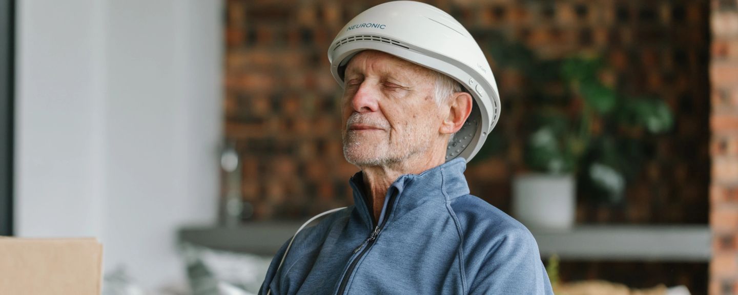 Man wearing Neuronic Helmet, eyes closed, in profile
