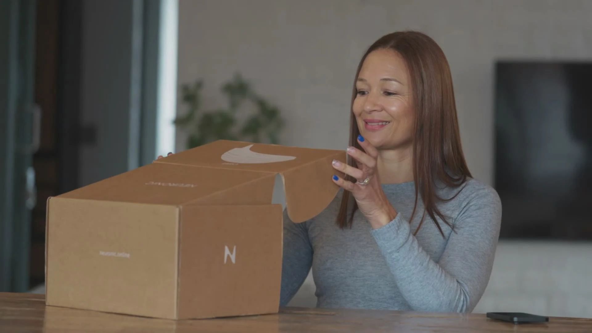 Woman unboxing the Neuronic LIGHT at her kitchen table