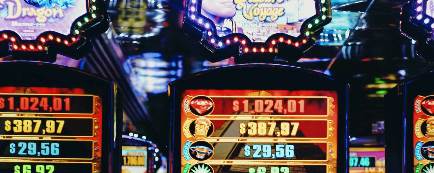 Slot machines displaying various monetary amounts with illuminated reels and decorative elements in a casino setting