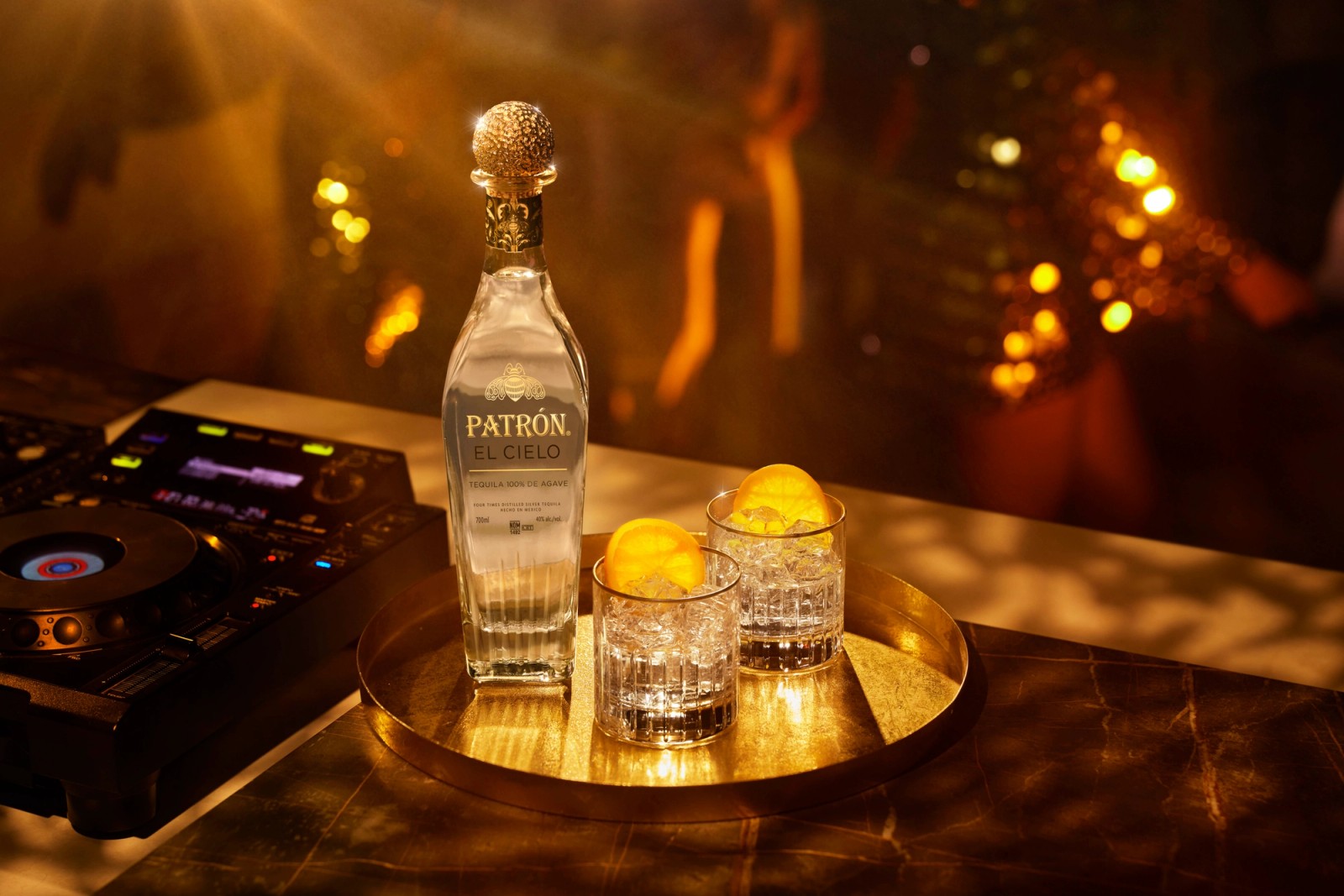 A bottle of Patron El Cielo with two serves and models dancing at a nightclub in Ibiza, photographed by Jason Bailey