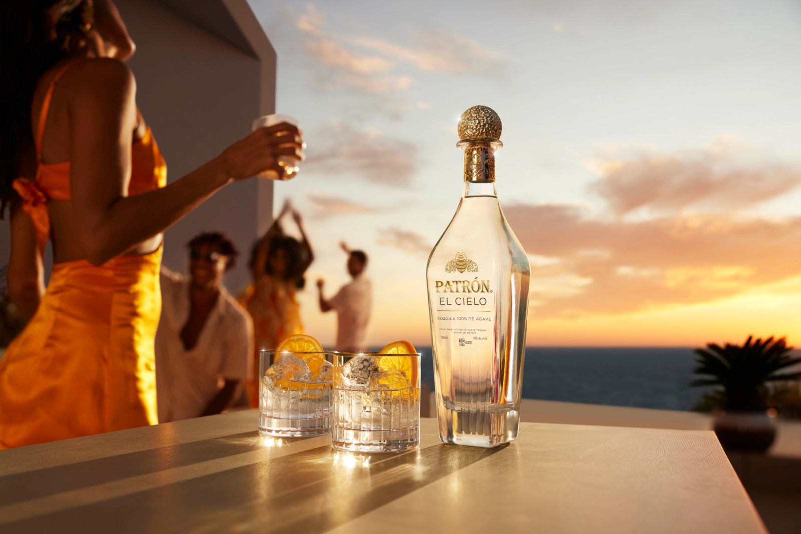 A bottle Patron El Cielo with two serves and models dancing at sunset in Ibiza, photographed by Jason Bailey