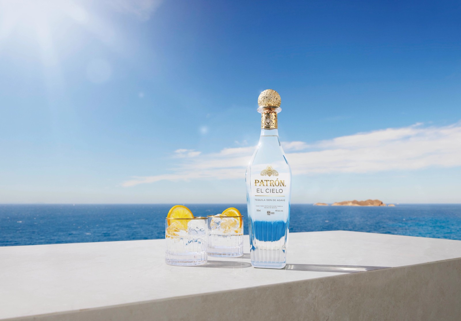 A bottle Patron El Cielo with two serves overlooking a vast seascape in Ibiza, photographed by Jason Bailey