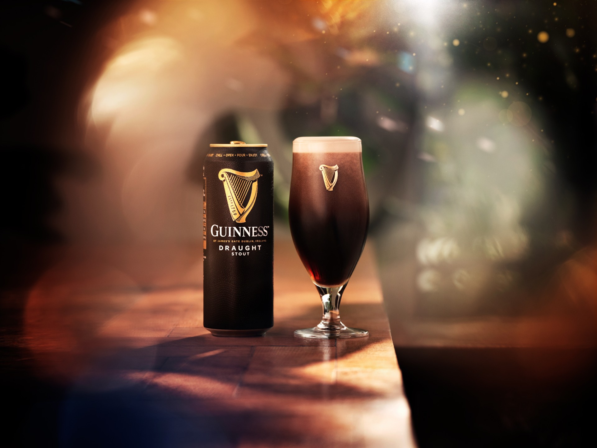 A pint of Guinness beside a can in twinkly light, photographed by Jason Bailey