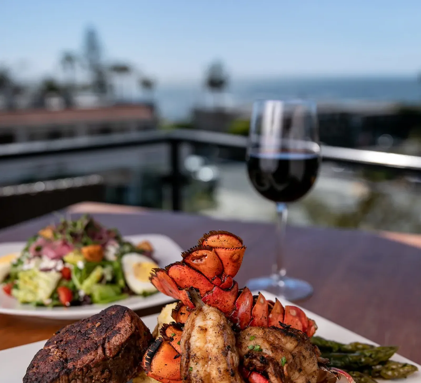 Surf and turf with grilled filet, lobster, and wine over the Laguna Beach coast at Mozambique