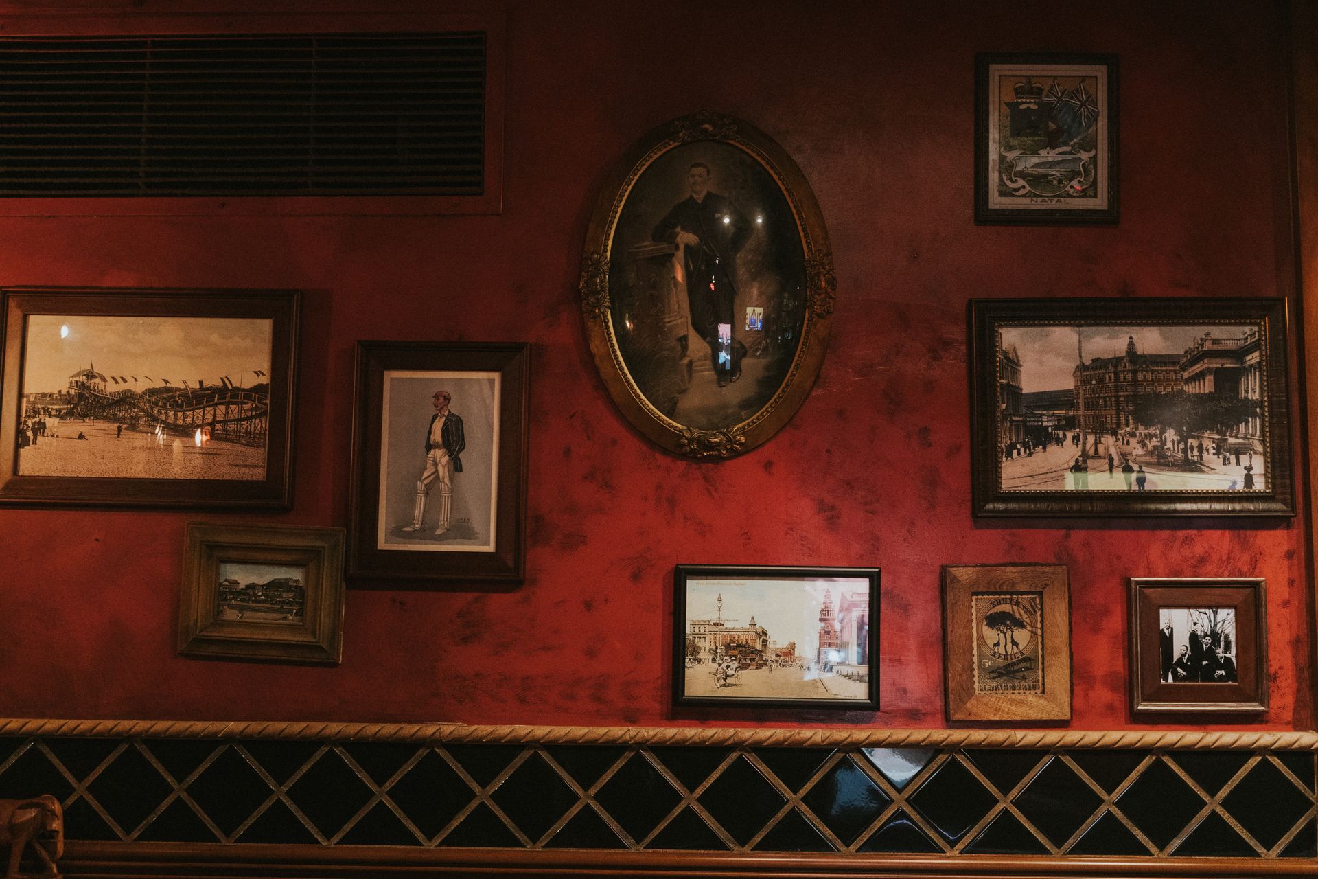 Framed vintage photographs on the Durban Room's red walls