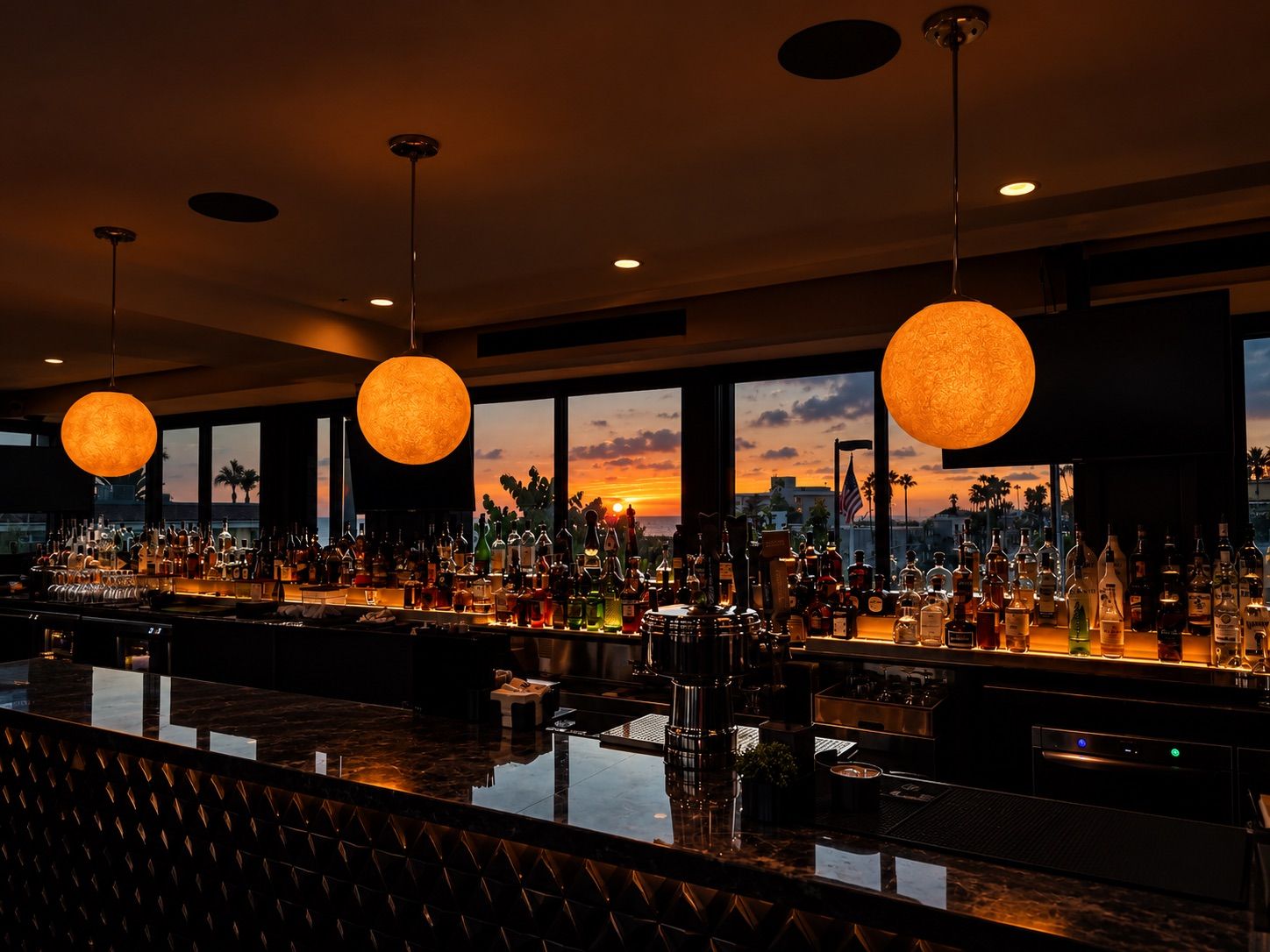 Ivan'z House bar glowing at sunset under globe pendant lights