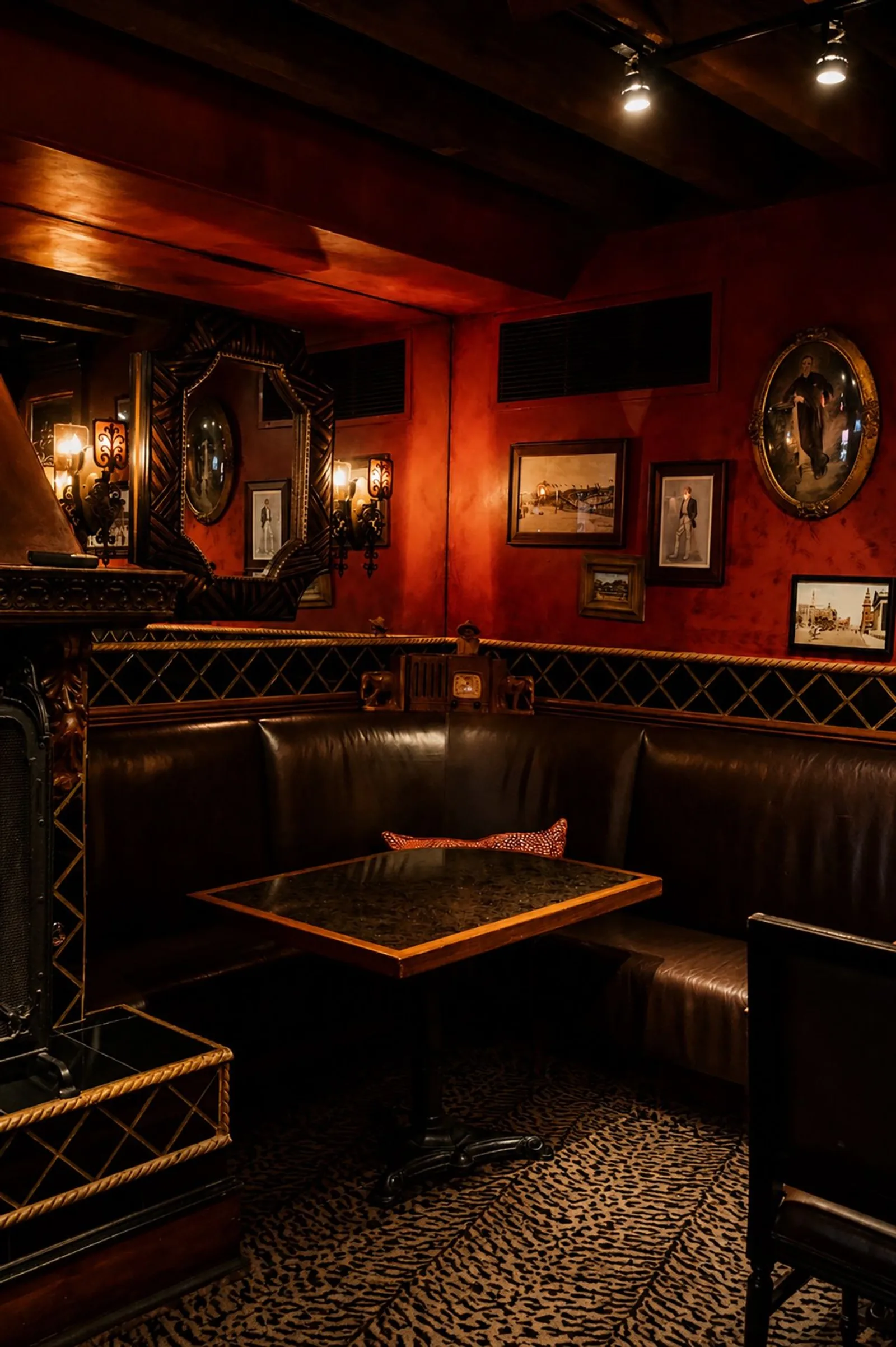 Leather corner booth in the Durban Room with framed art on red walls