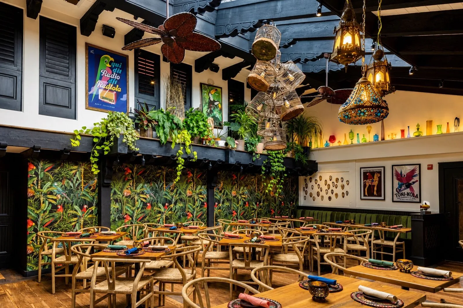Parrot Room dining tables beneath hanging plants and lanterns