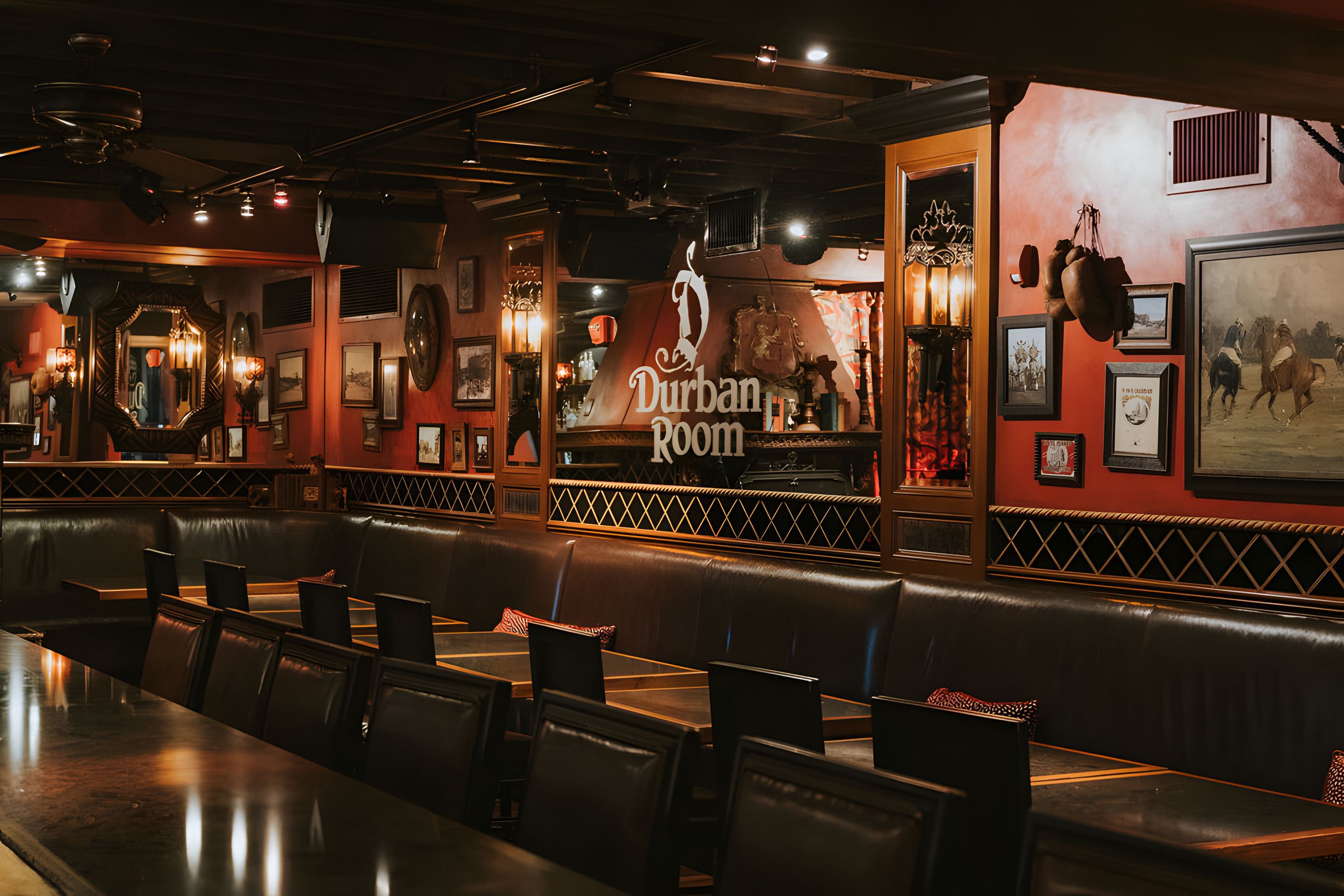 Dim wood-paneled Durban Room bar interior with leather booths