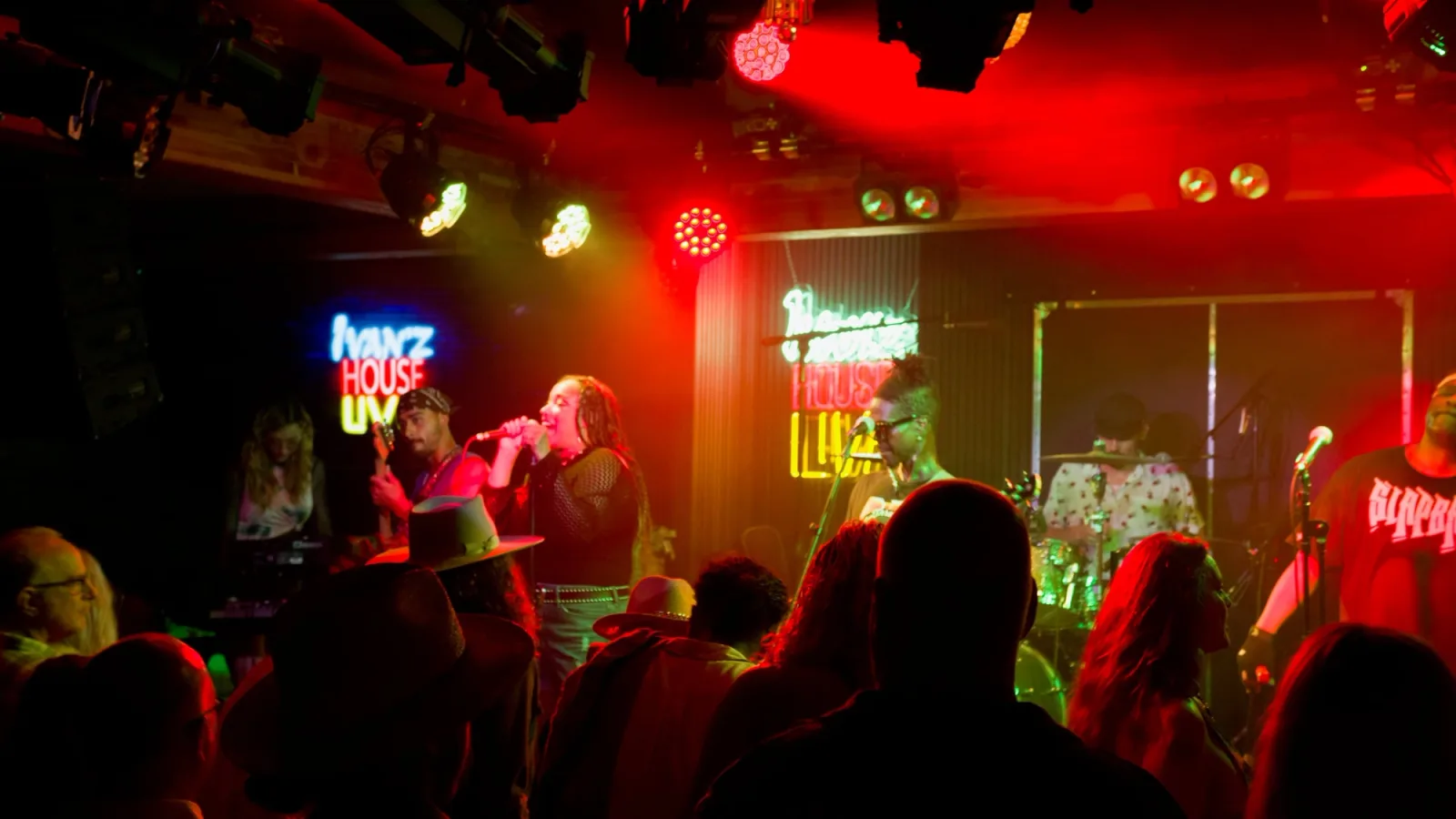 Band performing under red stage lights at Ivan'z House Live