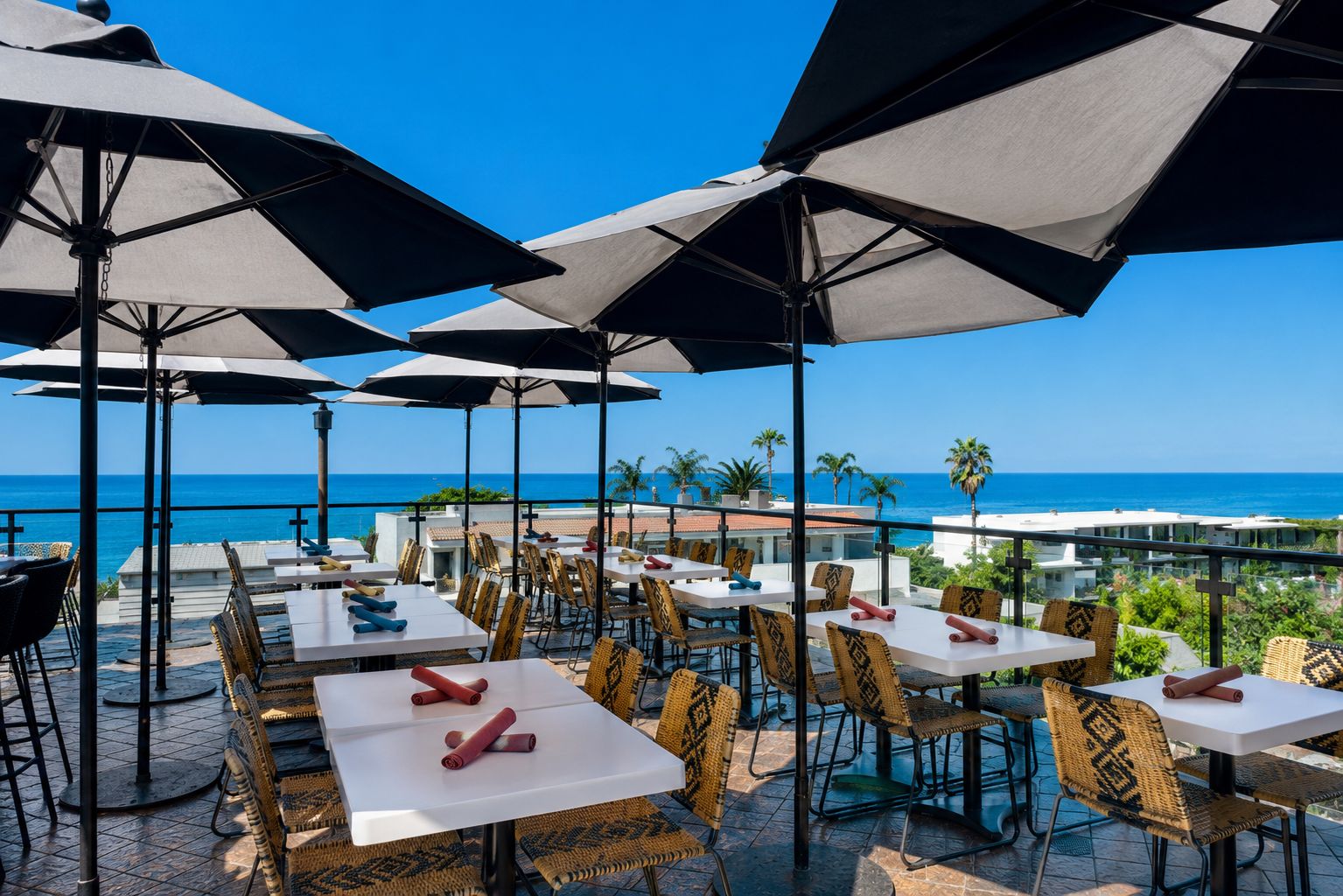 Veranda Rooftop dining tables under umbrellas with an ocean view