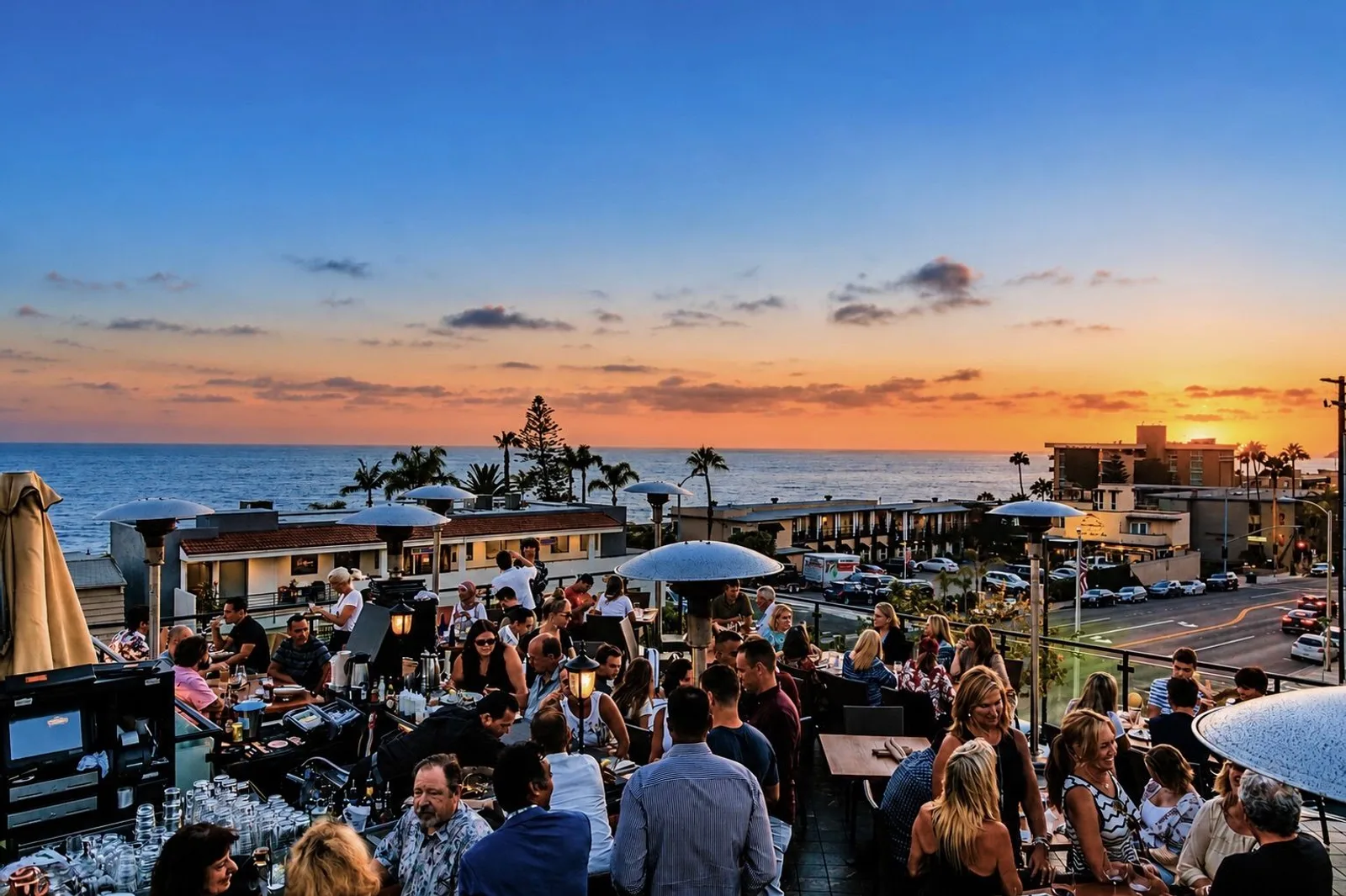 Guests gathered on the Veranda Rooftop at sunset over the ocean