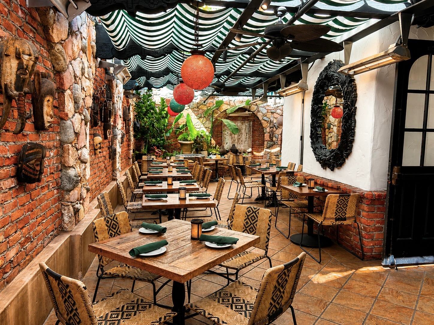 Garden Patio seen from the entry, with tables under striped awnings