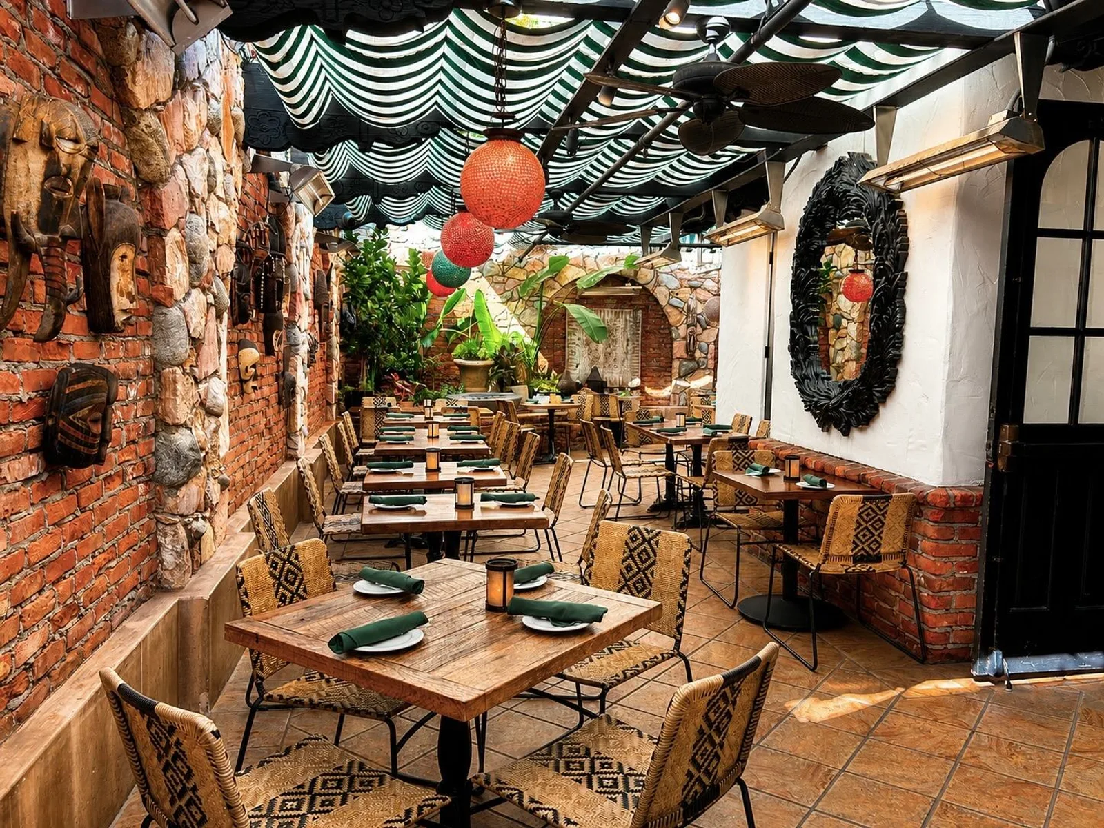 Garden Patio seen from the entry, with tables under striped awnings