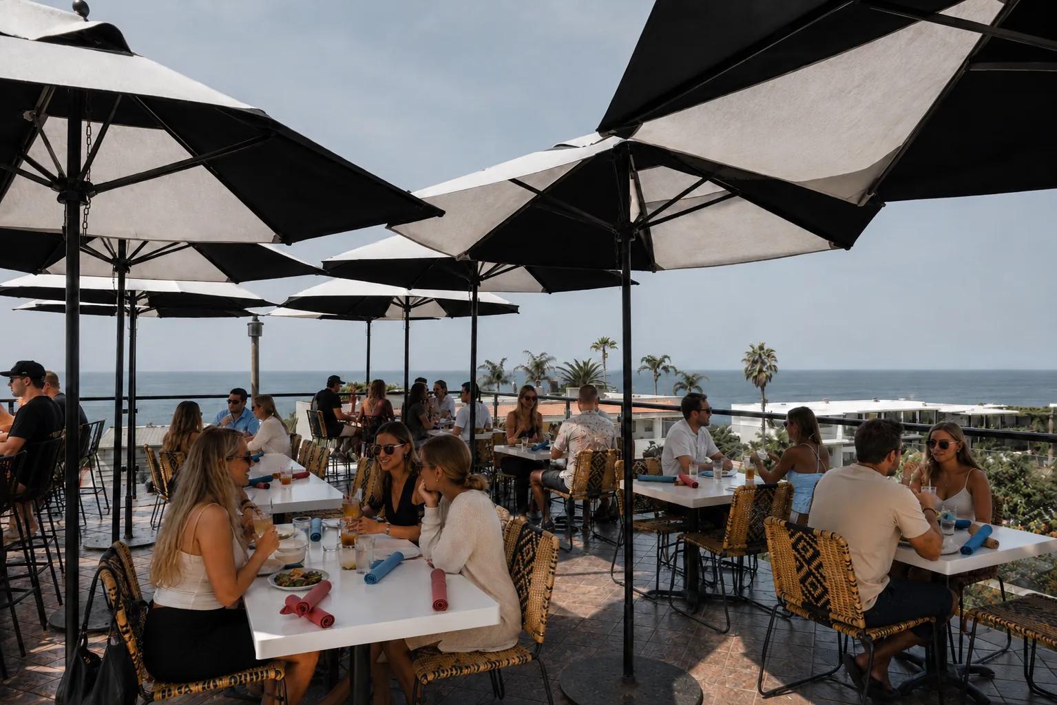 Guests dining beneath black-and-white umbrellas on Mozambique's ocean-view rooftop