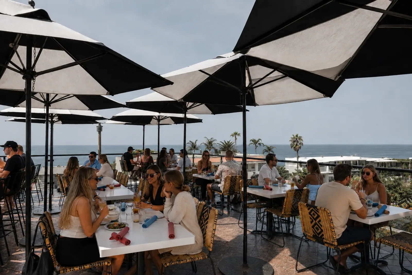 Guests dining beneath black-and-white umbrellas on Mozambique's ocean-view rooftop