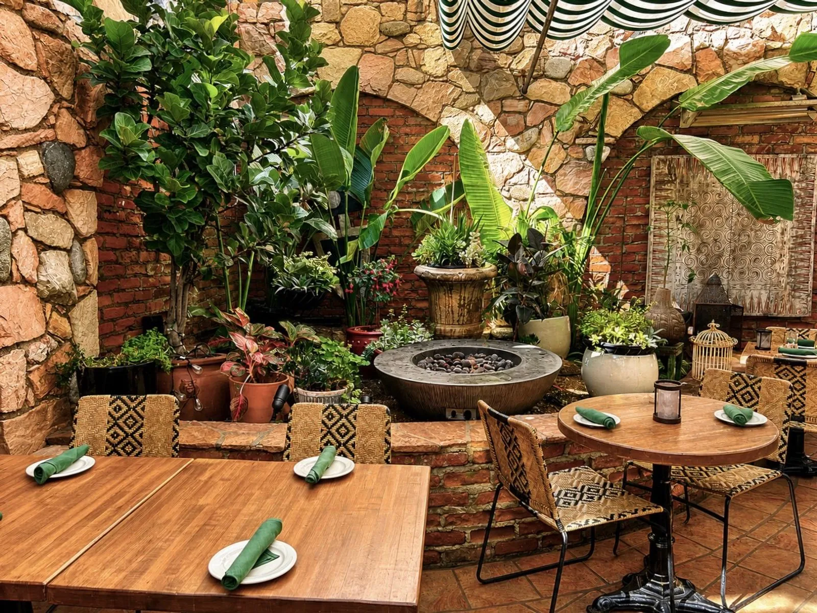 Fire pit and wood tables among potted plants on the Garden Patio