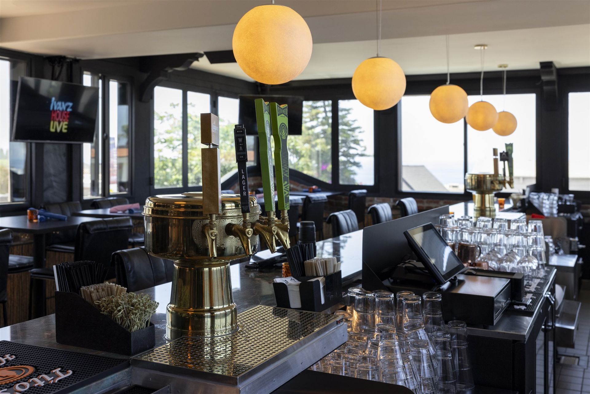 Ivan'z House bar with a brass beer tower and globe pendant lights