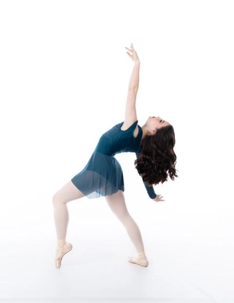 A dancer moves in a teal costume