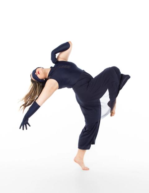 A dancer leaps in a navy costume