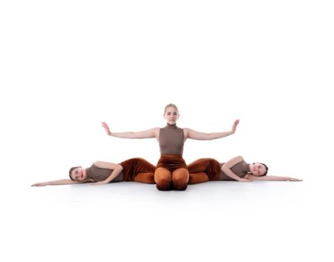 Dancers stretch together on the studio floor