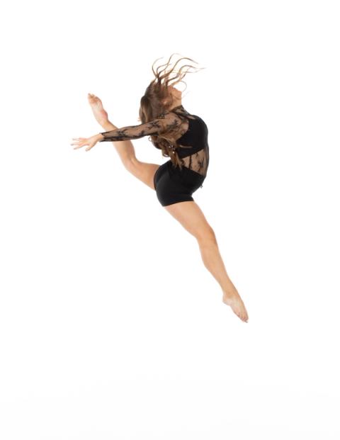A dancer leaps in a black costume