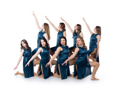 A group of dancers pose in teal costumes