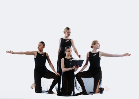 A group of dancers pose in black costumes